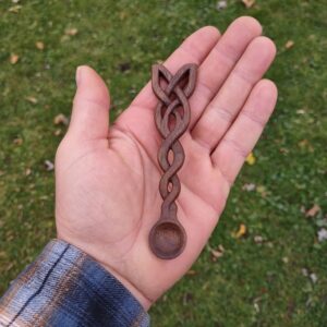 picture 1 of a celtic knot, hand carved from black walnut into a small spoon for incense powder